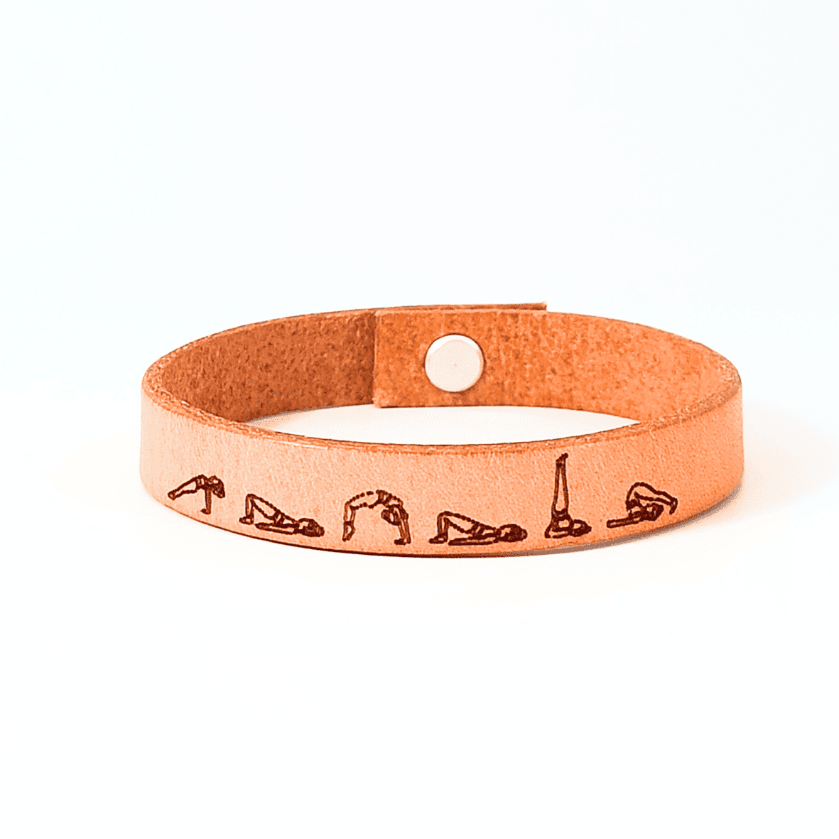 A brown leather bracelet with bridge yoga flow engraved on it.