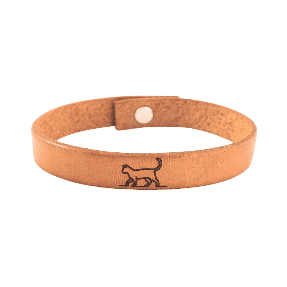 A brown leather bracelet with a cat engraved on it.