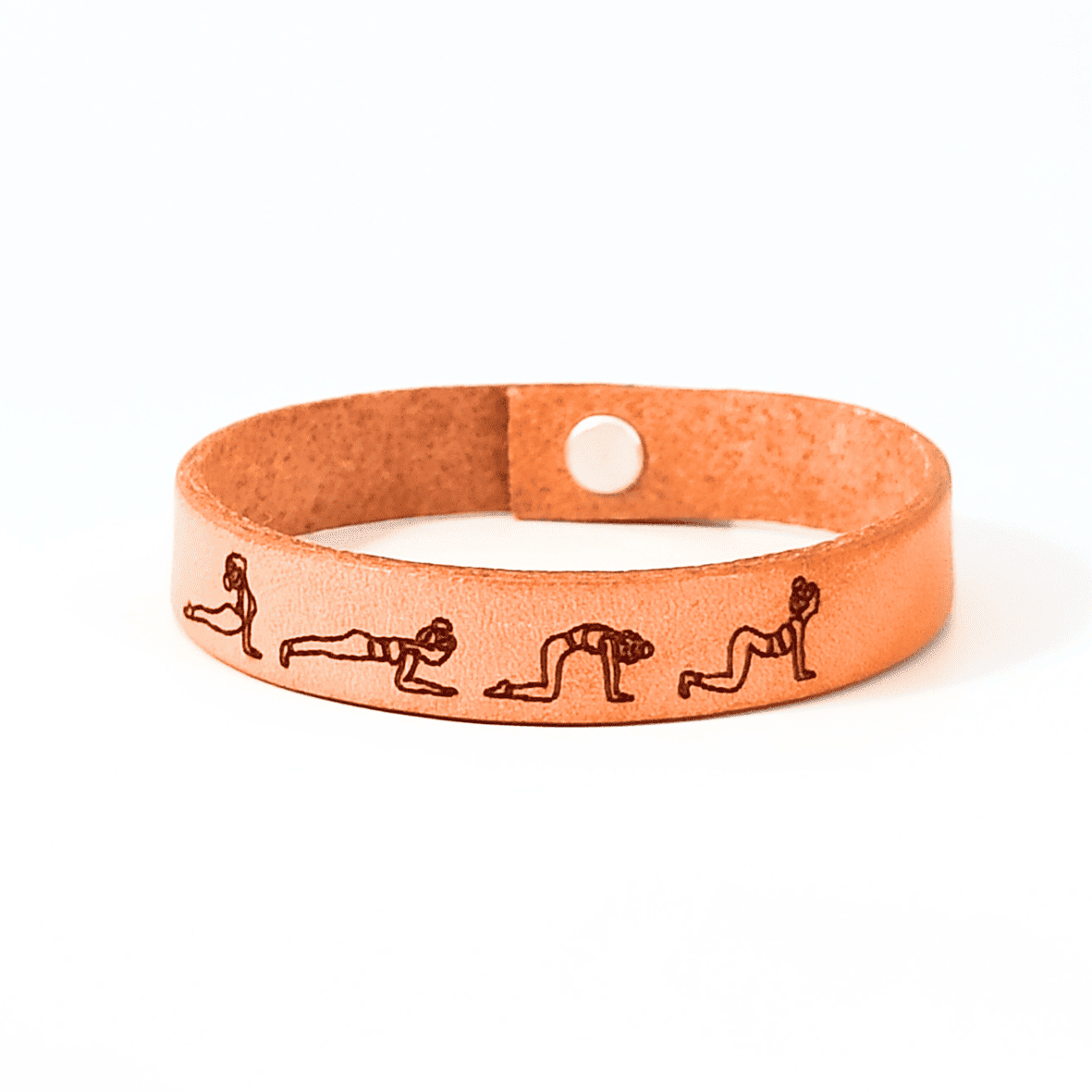 A brown leather bracelet with cat - cow yoga flow engraved on it.