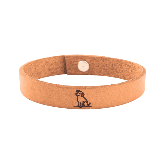 A brown leather bracelet with a dog engraved on it.