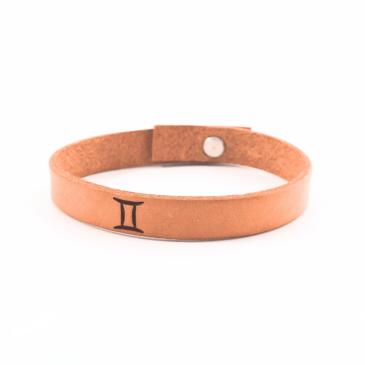 A brown leather bracelet with gemini´s symbol engraved on it.
