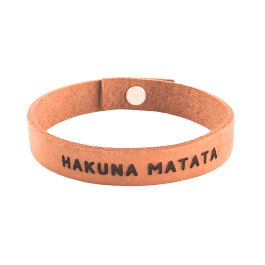 A brown leather bracelet with 'Hakuna Matata' engraved on it.