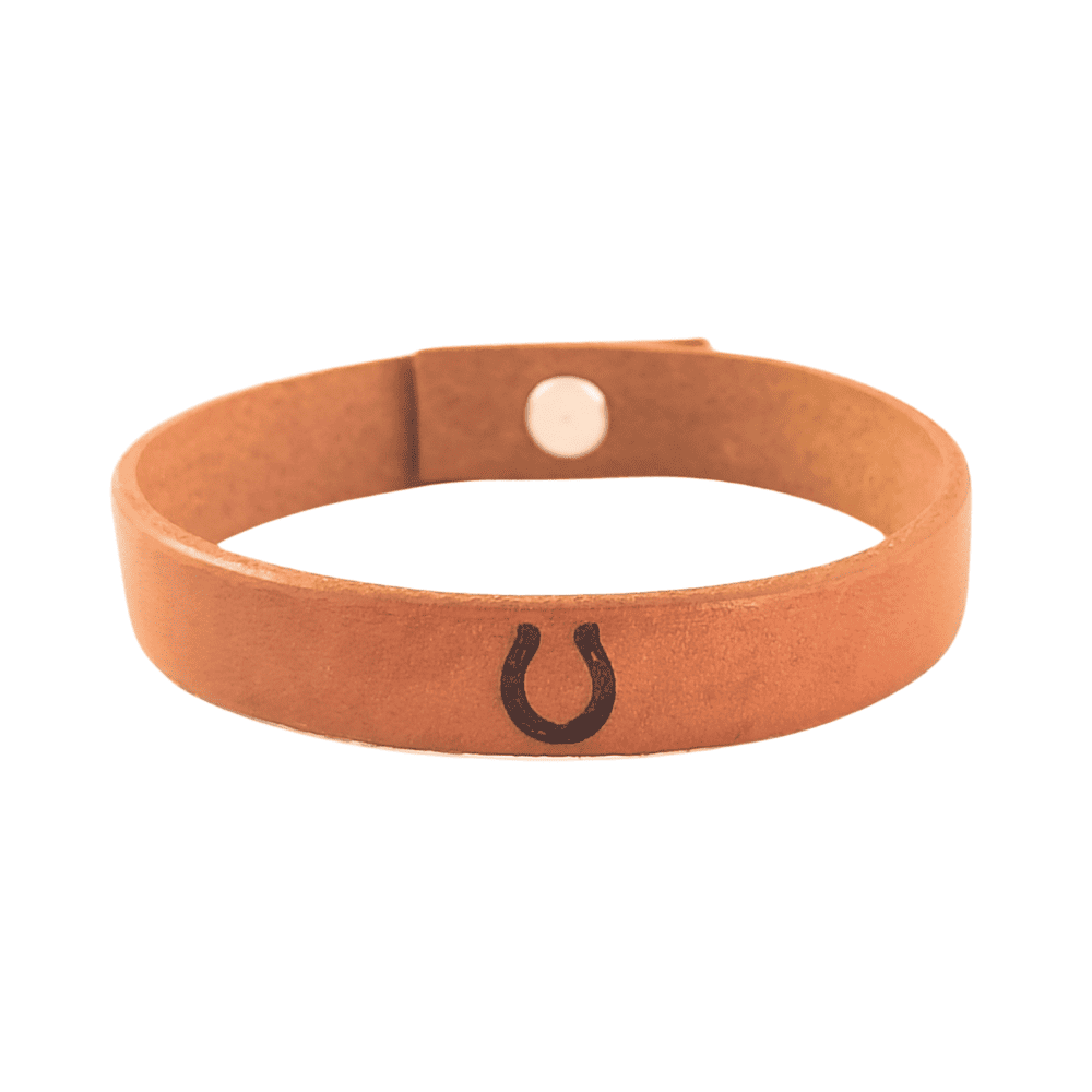 A brown leather bracelet with a horseshoe engraved on it.
