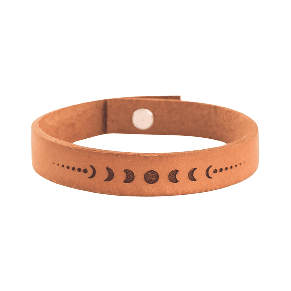 A brown leather bracelet with the lunar phases engraved on it.