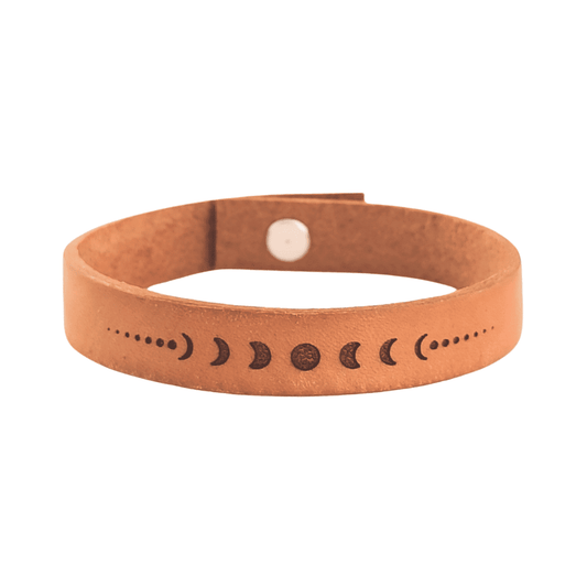 A brown leather bracelet with the lunar phases engraved on it.