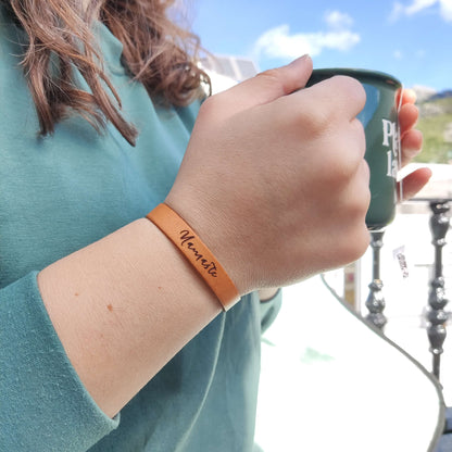 A brown leather bracelet with the phrase `Namaste´ engraved on it.