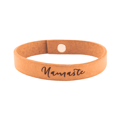A brown leather bracelet with the phrase `Namaste´ engraved on it.