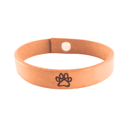 A brown leather bracelet with a paw print engraved on it.