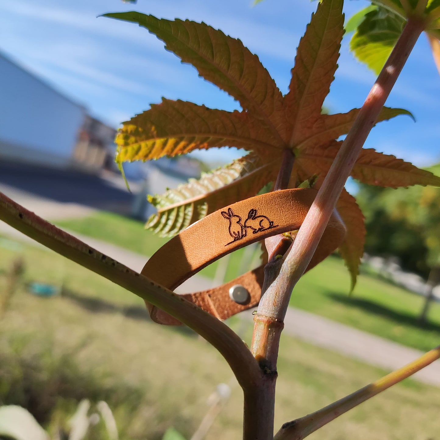 A brown leather bracelet with a pair of engraved on it.